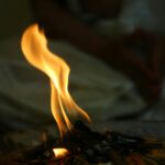 Close-up view of a mesmerizing flame engulfing firewood, creating warmth indoors.
