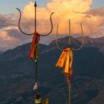 Vibrant sunset behind sacred tridents in Bijli Mahadev, Himachal Pradesh.